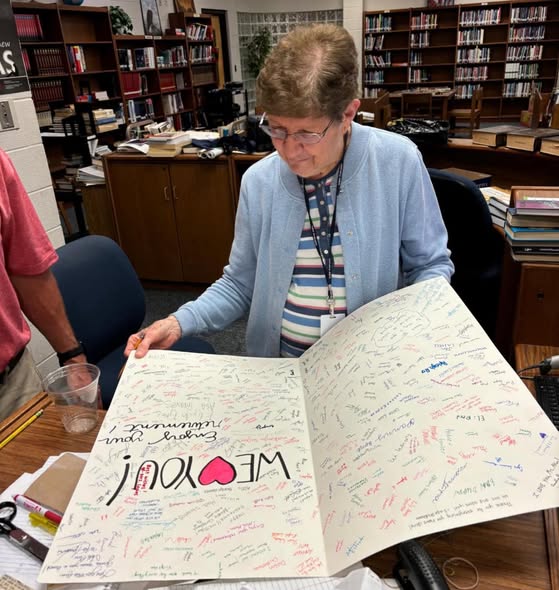 Teacher Breaks World Record For Teaching at the Same School for More Than 60 Years 2 Glenda Akin holding her Guinness World Record certificate surrounded by students and colleagues
