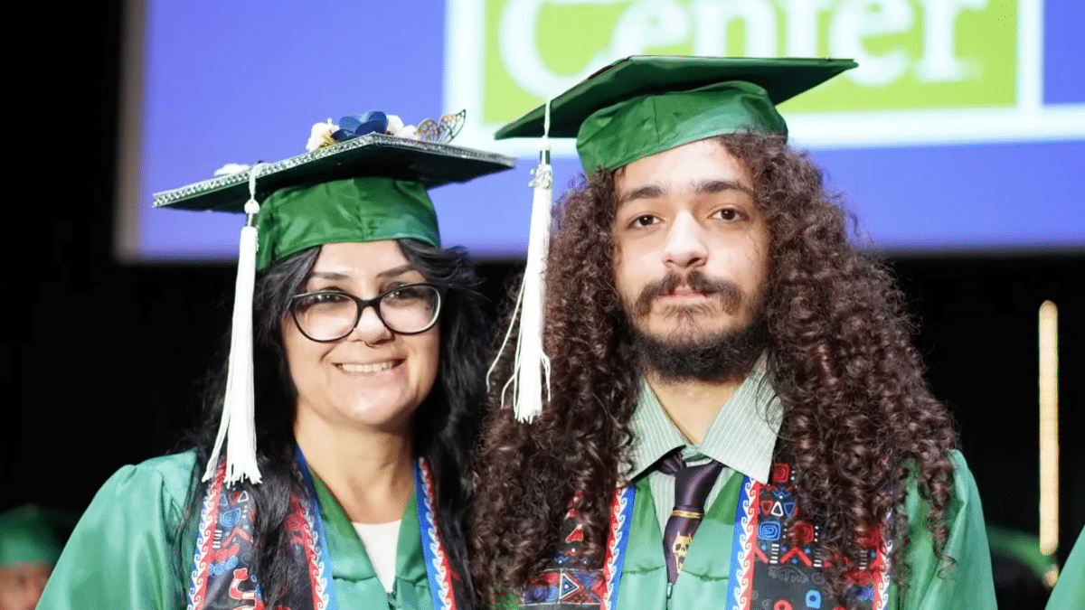 Educational News and Insights 1 Melody and Cecil Carrizosa in green graduation caps and gowns smiling together