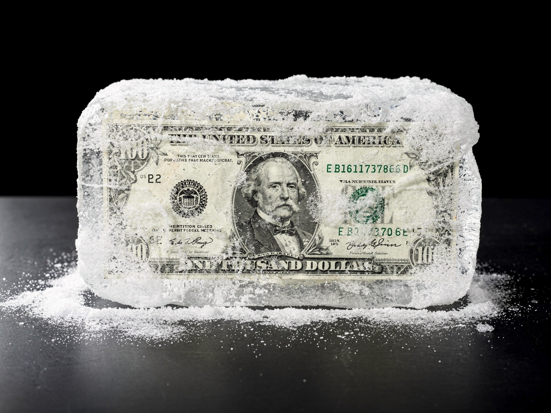 US dollar bill frozen inside a block of ice
