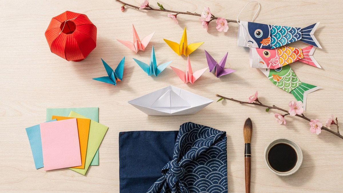 Japanese crafts for kids: origami cranes and a paper boat, koinobori carp streamers, a paper lantern, cherry blossom branches and a calligraphy brush